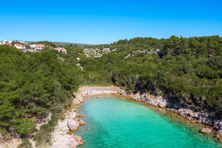 Drone shot looking at Redagara Beach with surrounding forest